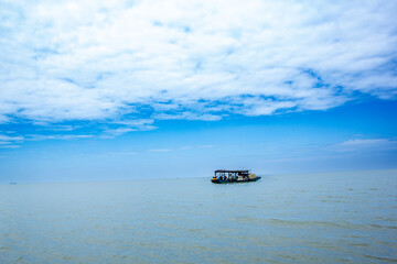 Obraz premium a boat with a blue sky and clouds in the background.