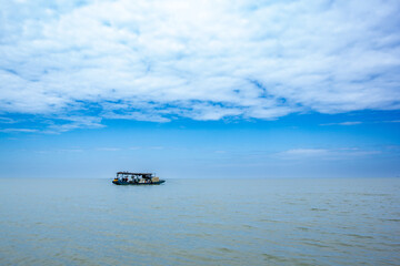 a boat with a blue sky and clouds in the background.