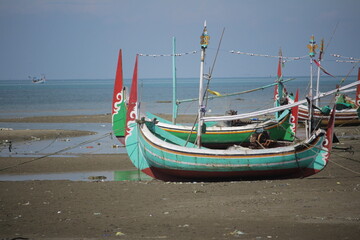 Obraz premium Traditional Fishing Boats Resting on a Sandy Shore