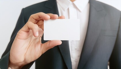 Hand holds a blank white name card in a professional setting