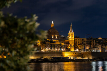 Obraz premium Valletta, Malta A night view of the skyline of the old town of Valletta, Ball's Bastion, and the Cathedral dome.