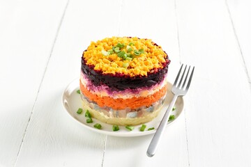 Layered vegetable salad with herring and boiled vegetables