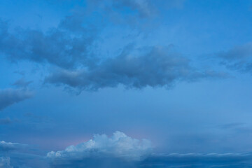 Dramatic cloudscape paints the blue sky with fluffy white clouds