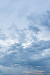 Beautiful fluffy white clouds drift across a bright blue summer sky