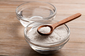 Baking soda powder in a spoon and bowl with mineral water - Healthy food