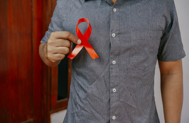 Aids red ribbon in doctor hand for World aids day and national HIV/AIDS and aging awareness month concept.
