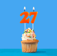 Orange candle number 27 - Birthday cupcake on blue background