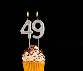 Number 49 shaped candles - Birthday cupcake on black background.