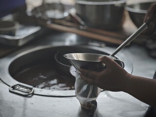 A noodle vendor's hands are making noodles, a famous Thai food.
