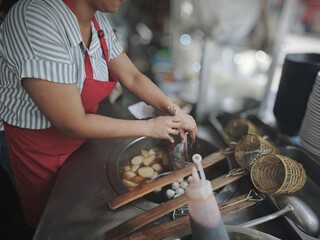 A noodle vendor's hands are making noodles, a famous Thai food.