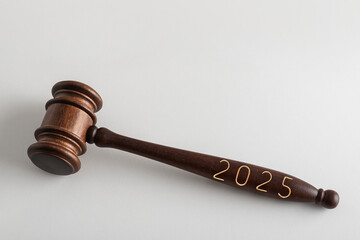 Lettering 2025 on judges gavel or hammer on white background. Court case in New Year