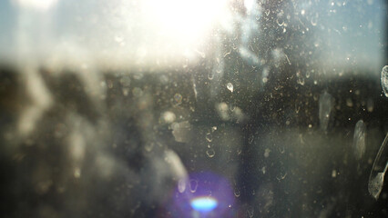Rays of sunlight passing through a dirty window pane on a clear summer day