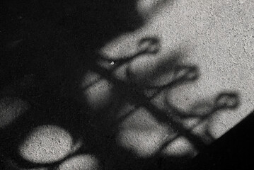 Shadow of fence on a road, black and white, top view.