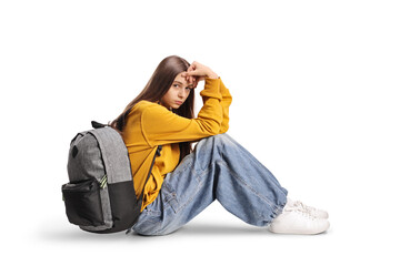 Sad female teenager sitting on the ground