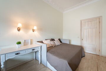 Luxury Home Retro Classic Bedroom Interior. King Size Bed, White Walls and Ceiling. Windows and Curtain. Old Coffee Table. Door in Background
