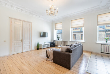 Modern Retro, Classic Style Home Living Room Interior with Open TV Area and TV Screen, Desk, Sofa, And Coffee Table. Flowers, Windows and Curtains in Background. Hardwood Floor,