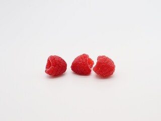 three raspberries on white background