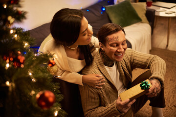 A couple enjoys a cozy moment together at home, celebrating the festive spirit of Christmas.