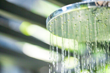 Outdoor pool bathroom open air style  with rain shower beside swimming pool in sunny day.