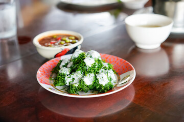 Bai Chakram with coconut cream served with Nam Prik Kapi or Thai shrimp paste chili sauce in the local restaurant. A famous healthy menu in Tambon Yi san, Samut Songkhram.