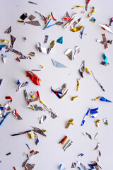 Colorful metallic confetti scattered on a white background creating a festive and celebratory vibe