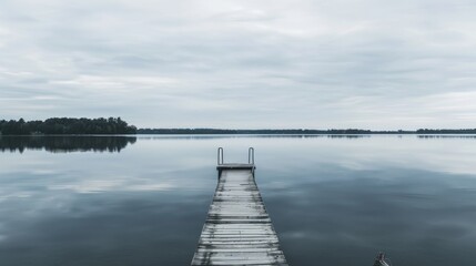 Fototapeta premium A spacious fishing dock extending into a serene lake, displaying a solitary fishing dock surrounded by calm, reflective waters
