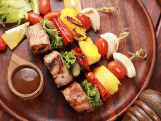 Barbecue grilled sliced ​​meat and vegetables on a wooden table