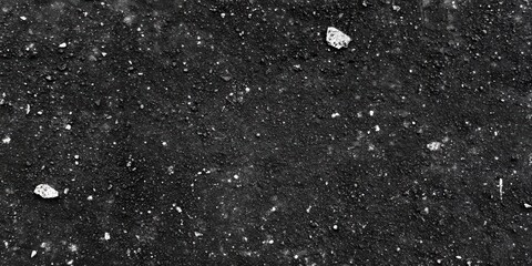 Dark textured surface featuring scattered rocks and stones, creating a natural and rugged background ideal for various design projects and artistic use.