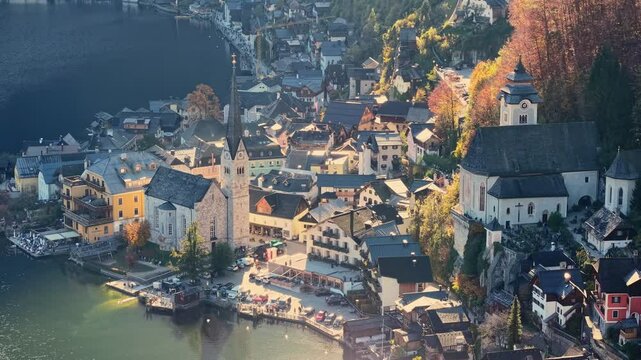 Fly over picturesque village of Hallstatt nestled in the Austrian Alps. Aerial tele shot of Evangelical Parish Church and old town in Hallstatt, Austria