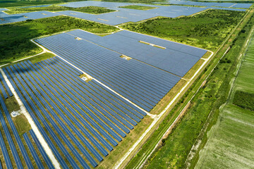 Aerial view of large sustainable electrical power plant with rows of solar photovoltaic panels for...