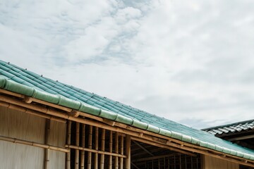 Traditional tiled roof under a clear sky with clouds.