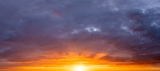 Bright colorful orange and yellow clouds on horizon. Beautiful sunset sky scenery