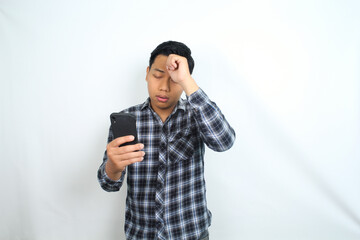 unhealthy asian man with migraine and fatigue using health care apps on smartphone isolated on white wearing casual shirt