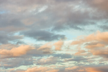 A beautiful sky tinted by the sun leaving vibrant shades of gold, pink, blue and multicolored. Clouds in the twilight evening and morning sky. Cloudy sky background in the evening, and during the day.