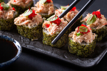 Japanese cuisine. Sushi rolls on a black platter
