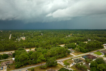 Landscape of dark ominous clouds forming on stormy sky before heavy thunderstorm over rural town...