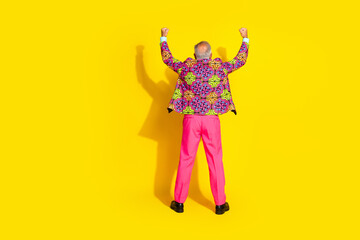 Full body rear portrait of grandfather raise fists empty space ad wear vibrant pink clothes isolated on yellow color background