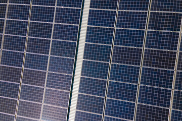 Obraz premium Photovoltaic panels on solar rooftops of commercial building for producing clean ecological electrical energy. Renewable electricity with zero emission concept