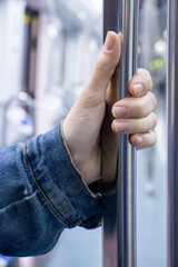 hand holding a bar inside a train