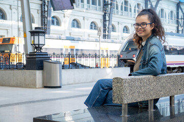 Young girl waiting for the train at a large European station