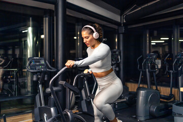 Beautiful woman exercising inside the gym for good shape and health.