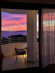 Fototapeta premium Romantic Balcony Sunset View from a Cozy Room