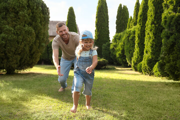 Fototapeta premium Father and his daughter spending time together on green lawn in park