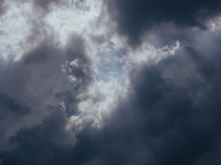 Rayos de sol filtrándose a través de un cielo densamente nublado, creando un efecto dramático y...