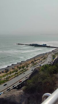 Turista contemplando el malec&oacute;n del distrito de Miraflores y el oc&eacute;ano Pac&iacute;fico desde el acantilado.