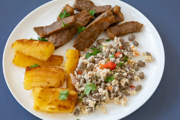 Traditional rustic tropical Brazilian dish, sun-dried beef with green beans, cassava, biquinho pepper. Creative rustic photography