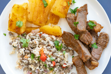 Traditional rustic tropical Brazilian dish, sun-dried beef with green beans, cassava, biquinho pepper. Creative rustic photography