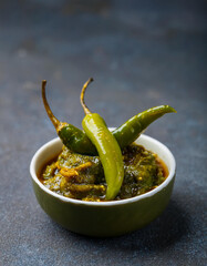 Green chili Achar in small bowl. Tasty homemade food. Cooking and culinary concept.