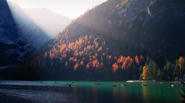 Lake Braies in Italy, scenic autumn landscape on an alpine lake in Italian Dolomites, sunset on Lago di Braies, row boats on the lake in the Dolomite Alps