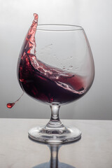 Red wine splashes in the glass 